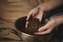 Person holding fresh roasted beans — Stock Photo