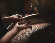 Pessoa segurando punhado de grãos de café — Fotografia de Stock