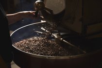 Tambor de metal con granos de café tostados - foto de stock