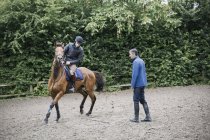 Mann reitet Pferd auf Koppel — Stockfoto