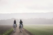 Cavaliers à cheval le long du sentier — Photo de stock