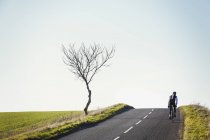 Педали велосипедиста вдоль проселочной дороги — стоковое фото