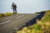 Cycliste le long de la route de campagne — Photo de stock