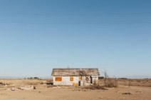 Casa in legno abbandonata in un paesaggio arido — Foto stock