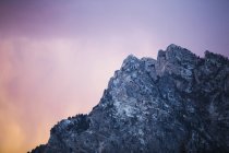 Montaña rocosa contra cielo colorido - foto de stock