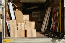 Van de mudanzas con cajas apiladas y artículos - foto de stock