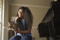 Дівчина з домашнім котом на колінах — стокове фото