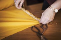 Женщина с помощью рулетки для желтой ткани — стоковое фото