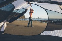 Homem em pé na praia e olhando através de binóculos — Fotografia de Stock