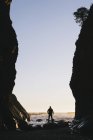Uomo in piedi tra alte scogliere al crepuscolo — Foto stock