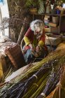 Mujer tejiendo cesta - foto de stock