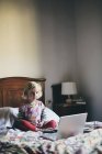 Mädchen sitzt auf Bett im Hotelzimmer — Stockfoto