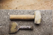 Hammer und Meißel auf Betonplatte. — Stockfoto