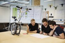 Homens em uma reunião em uma fábrica de bicicletas , — Fotografia de Stock