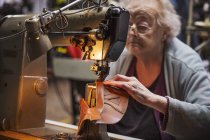Older woman in a shoemaker's workshop. — Stock Photo