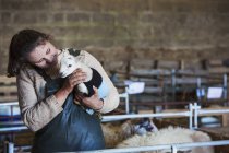 Woman holding newborn lamb — Stock Photo