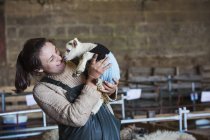 Woman holding newborn lamb — Stock Photo