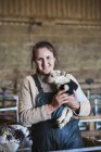 Femme tenant un agneau nouveau-né — Photo de stock