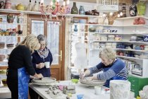 Three women in a pottery studio — Stock Photo