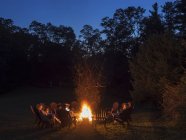 People seated around campfire — Stock Photo