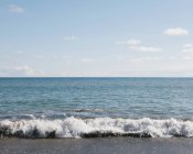 Sandy beach and waves — Stock Photo