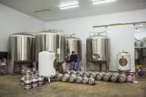 Homme remplissant barils de bière en métal — Photo de stock