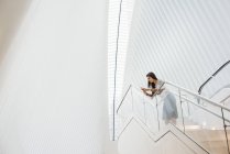 Mulher na escada inclinando-se sobre trilhos — Fotografia de Stock