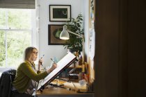 Жінка малює з верстатом — стокове фото