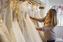 Asistente de ventas en la tienda de vestidos de novia - foto de stock