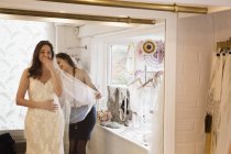 Mulher tentando no vestido de noiva — Fotografia de Stock