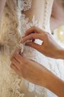 Dressmaker taking in wedding dress — Stock Photo