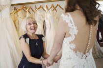 Жінка намагається на весільних сукнях — стокове фото