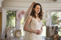 Молода жінка намагається на весільних сукнях — стокове фото