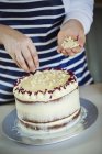 Kuchen mit Sahne und lila Blütenblättern. — Stockfoto