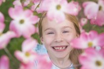Junges Mädchen blickt durch die Blüte — Stockfoto
