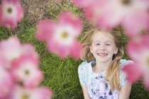 Junges Mädchen blickt durch die Blüte — Stockfoto