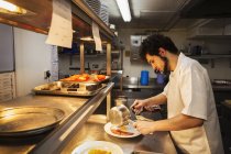 Chef standing in restaurant kitchen — Stock Photo