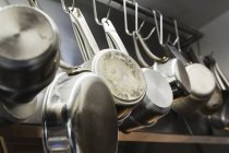 Горщики і сковороди, що звисають на металевих гачках — стокове фото