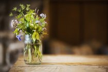 Glass jar with wild flowers — Stock Photo