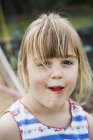 Sorrindo menina comendo um morango — Fotografia de Stock