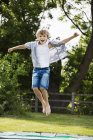 Мальчик прыгает на батуте — стоковое фото