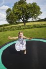 Fille sautant sur trampoline — Photo de stock