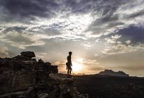 Альпинист, стоящий на вершине скалы — стоковое фото