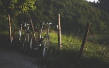 Bicicletas apoyadas contra la cerca desvencijada - foto de stock