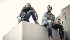 Paar sitzt auf dem Dach der Stadt. — Stockfoto
