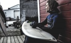 Surfer sitting  with surfboard — Stock Photo