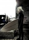 Surfista que lleva una tabla de surf - foto de stock