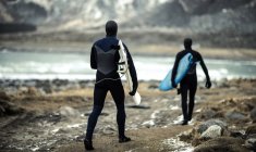 Surfisti che trasportano tavole da surf — Foto stock