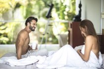 Uomo e donna seduti sul letto — Foto stock