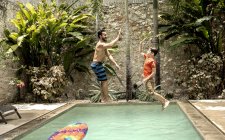 Мужчина и мальчик прыгают в бассейн . — стоковое фото